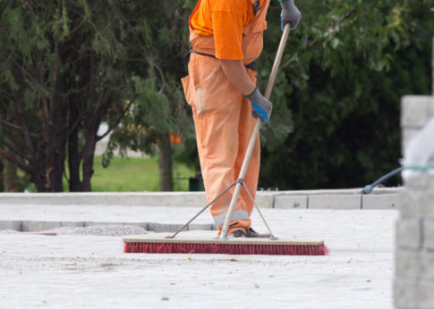 Construction worker sweeping on the building site