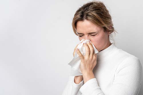 Mujer joven con síntomas de alergias