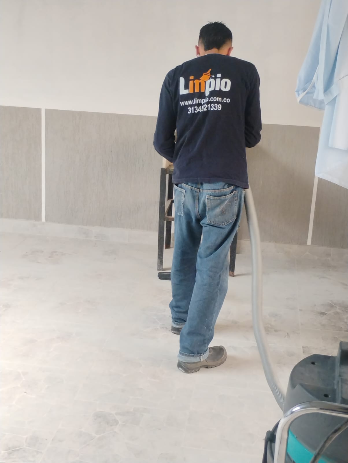 Operario uniformado de Limpio aspirando un piso con equipo industrial
