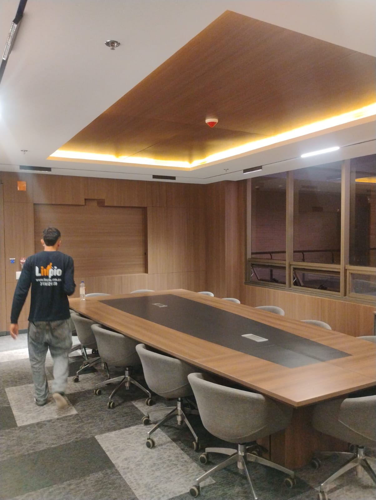 Operario de Limpio realizando limpieza en una sala de juntas corporativa